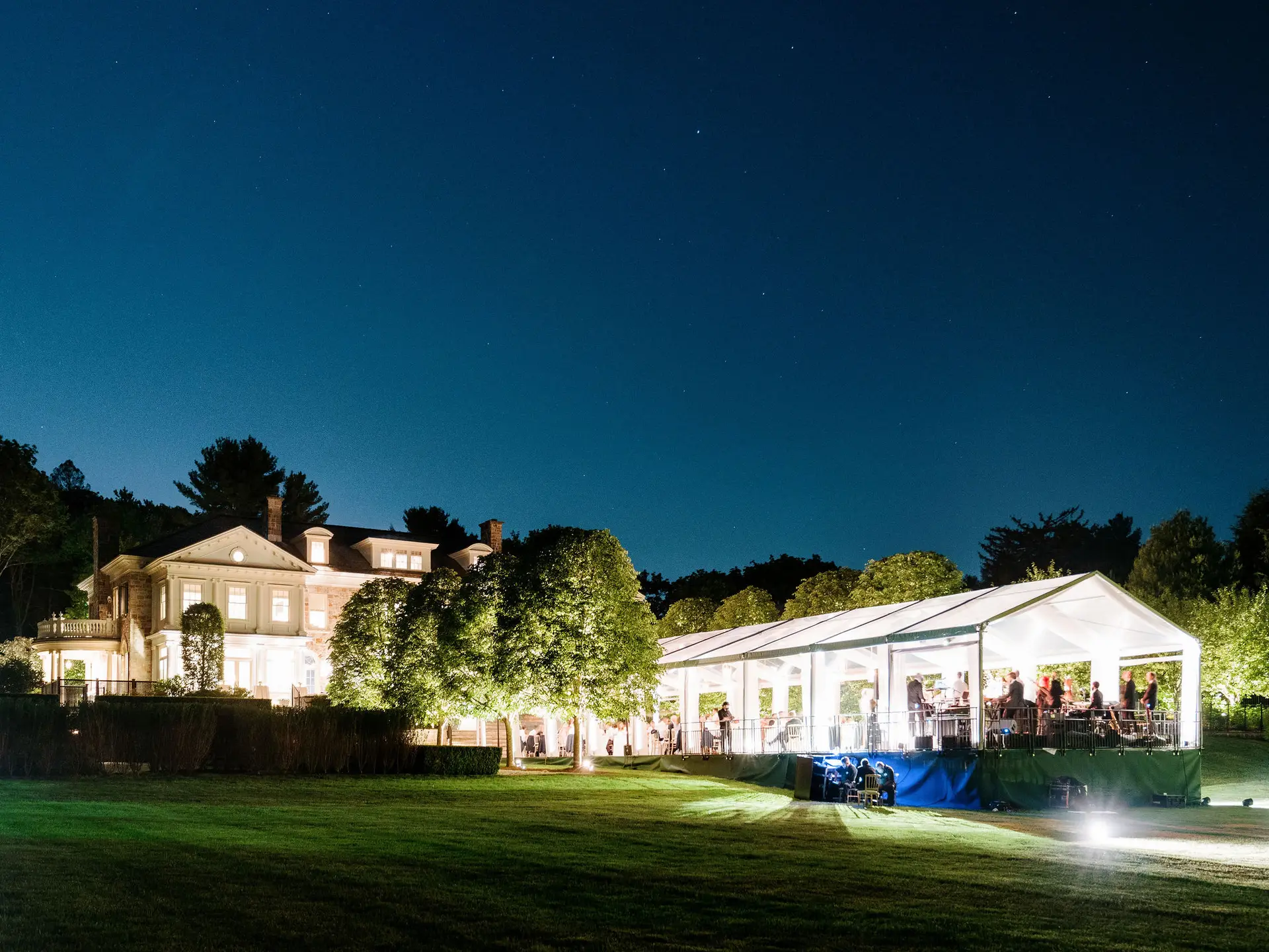 Exterior night time clear span clear top Losberger structure on private estate