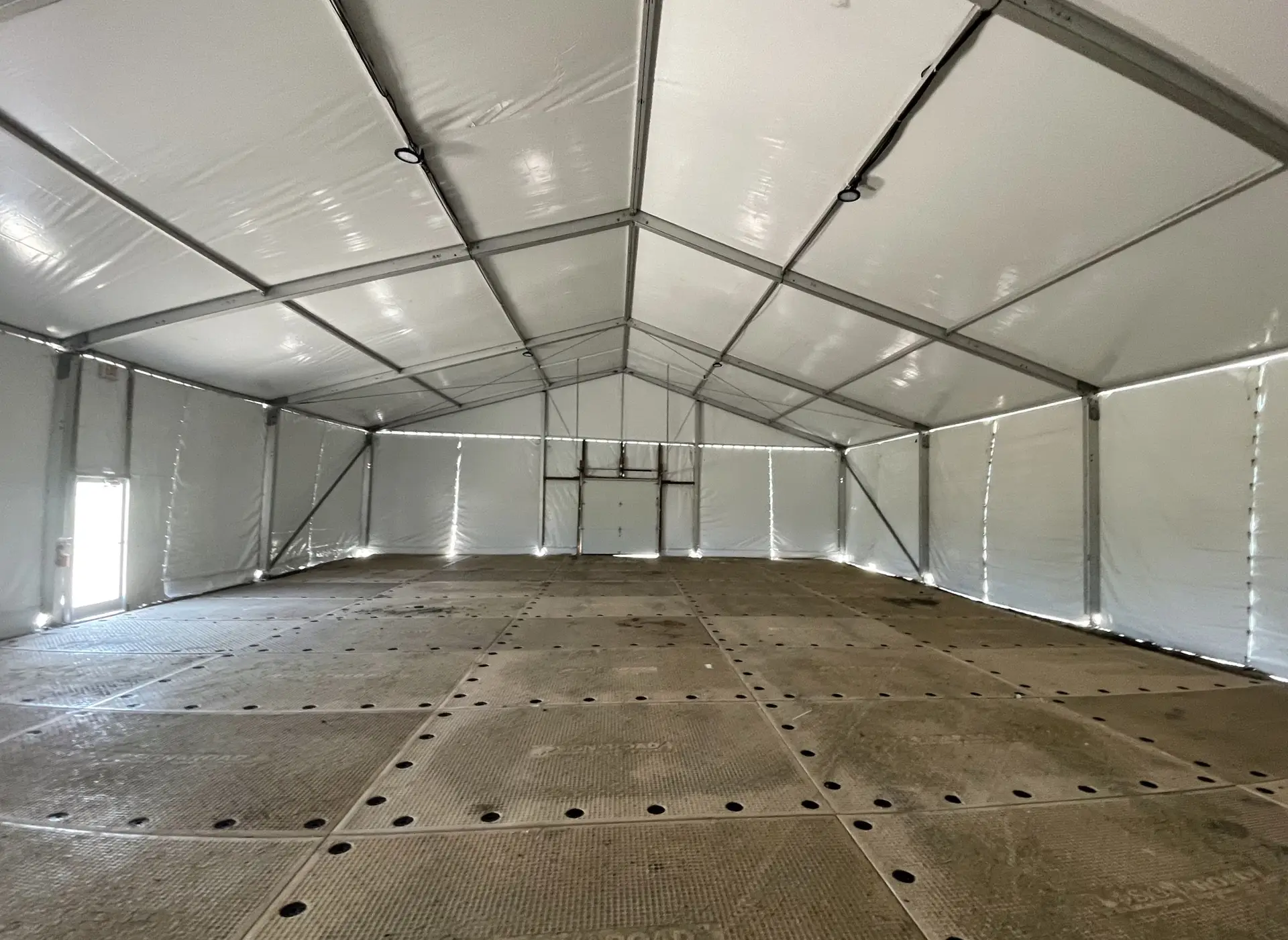Interior daytime naked clear span white top Losberger structure with full floor