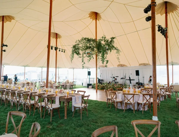Daytime interior of Sperry sailcloth tent, on grass, floral decor