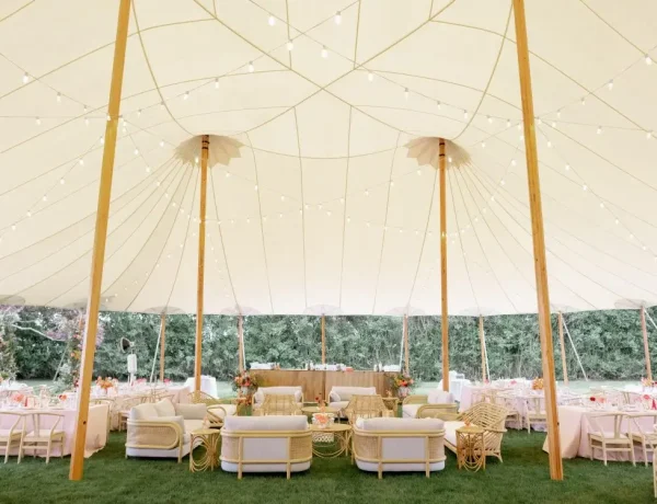 Daytime interior of Sperry sailcloth tent, on grass, floral decor