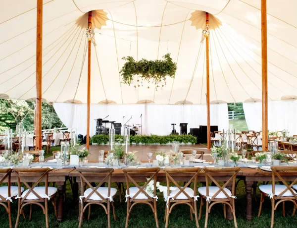 Daytime interior of Sperry sailcloth tent,on grass, floral decor